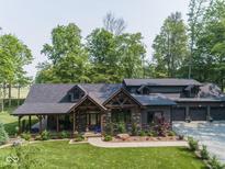 Beautifully landscaped home featuring a covered front porch, stone facade, and a well-maintained lawn at 2004 Layton Rd, Anderson, IN 46011