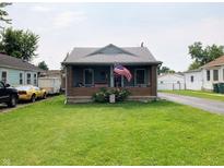 Charming single-story home featuring a brick front porch with a well-manicured lawn at 2032 N Auburn St, Speedway, IN 46224