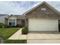 Charming brick home with a well-manicured lawn and two car garage at 2302 Rolling Oak Dr, Indianapolis, IN 46214