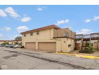 Two-story home with a terra cotta roof, two garage doors, and a stairway leading to an upper deck at 2766 Del Prado Dr # 6, Indianapolis, IN 46227