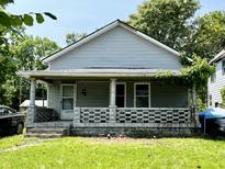 Two story home with a covered front porch and a lawn at 2826 Station St, Indianapolis, IN 46218