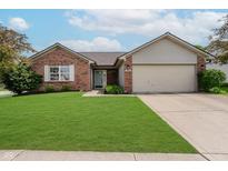 Charming brick home features a manicured lawn, attached garage, and inviting light blue front door at 293 E Quail Wood Ln, Westfield, IN 46074