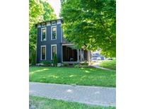 Charming two-story home with dark siding, white trim, a covered porch, and a well-manicured lawn at 321 N Rangeline Rd, Carmel, IN 46032