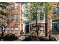 Charming brick townhome featuring a black front door and lush green tree in front at 420 Beverly Ct, Carmel, IN 46032
