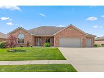 Charming brick home with a manicured lawn, attached garage and beautiful landscaping at 5229 Imperial Dr, Columbus, IN 47203