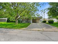 Charming single-story home featuring a well-manicured lawn, mature tree, and a convenient attached carport at 623 Circle Ct, Whiteland, IN 46184