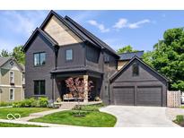 Stunning two-story home featuring a dark exterior, a two-car garage, and a charming front porch at 631 1St Nw Ave, Carmel, IN 46032