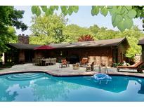 Inviting backyard oasis with pool, brick patio, and ample seating for outdoor entertaining at 6519 Creekside Ln, Indianapolis, IN 46220