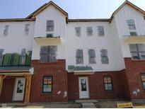 Modern townhome exterior featuring brick and white siding, and multiple windows at 7063 Pate Hollow Dr, Brownsburg, IN 46112