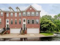 Brick townhouse with gray shutters, attached garage, and manicured lawn at 755 Ivy Ln, Carmel, IN 46032