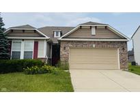 Charming home featuring a brick facade, tan siding, and a two-car garage at 8176 Crumwell Dr, Avon, IN 46123