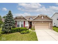Charming single Gathering home features a well-maintained lawn, mature landscaping, and a two-car attached garage at 8176 Crumwell Dr, Avon, IN 46123