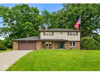 Charming two-story home featuring a well-manicured lawn, brick accents, and an attached two-car garage at 955 Wood Creek Pl, Greenwood, IN 46142