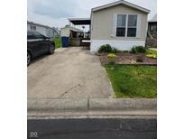 This property features a concrete driveway, covered porch, well-manicured lawn, and tidy landscaping at 10129 Peartree Rd, Indianapolis, IN 46235