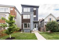 Modern home showcasing a stylish exterior with blue and wood accents and a well-manicured front lawn at 1452 Fletcher Ave, Indianapolis, IN 46203