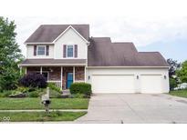 Charming two-story home featuring a two-car garage, well-manicured lawn, and a welcoming front porch at 1477 Macintosh Ct, Avon, IN 46123