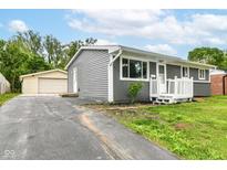 Charming single-story home with gray siding, white trim, well-maintained lawn, and a detached two car garage at 1820 Hemlock Ln, Plainfield, IN 46168