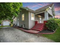Charming home with red steps, landscaped yard, and detached garage at 1915 Albany St, Beech Grove, IN 46107