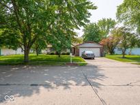 Charming single-story home featuring a well-manicured lawn, mature trees, and an attached two-car garage at 3303 Wedgewood Dr, Indianapolis, IN 46227