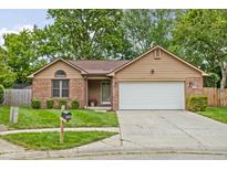Charming single-story home featuring a manicured lawn, brick accents, and an attached two-car garage at 3304 Fox Orchard Cir, Indianapolis, IN 46214