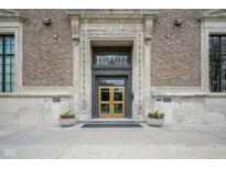 Elegant building entrance with decorative stone surround and symmetrical planter boxes at 350 N Meridian St # 505, Indianapolis, IN 46204