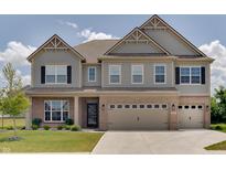 Charming two-story home showcasing a blend of brick and gray siding, complemented by a well-manicured lawn at 4163 Ironclad Dr, Bargersville, IN 46106