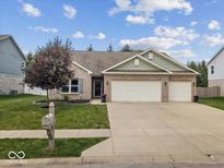 Charming brick home featuring a well-maintained lawn and two-car garage, perfect for suburban living at 4736 Blue Marlin Way, Indianapolis, IN 46239
