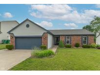 Charming single-story home featuring a brick facade, well-manicured lawn, and attached two-car garage at 488 Village Blvd, Mooresville, IN 46158