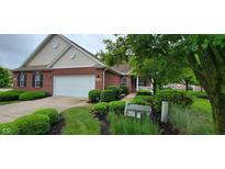 Charming brick home with a two-car garage and inviting landscaping with lush green bushes at 5189 Bally Bunion Dr, Avon, IN 46123
