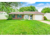 Charming single-story home with a well-manicured lawn, attached garage, and inviting curb appeal at 5401 Padre Ln, Indianapolis, IN 46237