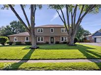 Charming two-story home with brick and siding, mature trees and a well-manicured lawn at 567 Hawthorne Dr, Carmel, IN 46033