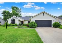 Charming ranch home featuring a well-manicured lawn, a gray garage door, and manicured shrubs at 572 Quail Ridge Dr, Westfield, IN 46074
