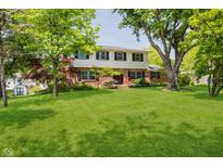 Charming two-story home featuring a manicured lawn and mature trees at 6146 Rucker Rd, Indianapolis, IN 46220
