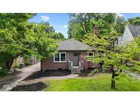 Charming single-story red brick home with a well-maintained lawn and mature trees at 6477 N Park Ave, Indianapolis, IN 46220
