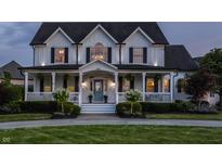 Beautiful two story home with a charming front porch, white siding and dark shutters, and a well manicured front yard at 6685 Chapel Xing, Zionsville, IN 46077