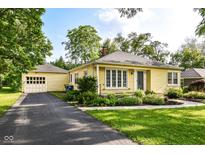 Charming yellow home with well-manicured lawn and detached garage and drive at 713 W Cromer Ave, Muncie, IN 47303