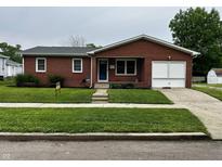 Charming brick home featuring a well-maintained front yard and an attached garage at 719 Henry St, Lebanon, IN 46052
