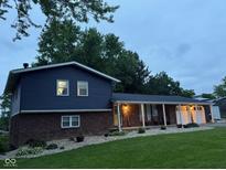 Charming two-story home with a brick base, blue siding, covered porch, and well-manicured front yard at 75 Byram Blvd, Martinsville, IN 46151