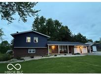 Charming split-level home featuring a brick facade, blue siding, covered porch and large garage at 75 Byram Blvd, Martinsville, IN 46151