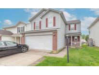 Charming two-story home features a two-car garage, red shutters, and a well-maintained lawn at 8056 Maple Stream Blvd, Indianapolis, IN 46217