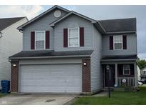 Traditional two-story home featuring a two-car garage, red shutters and vinyl siding at 8056 Maple Stream Blvd, Indianapolis, IN 46217