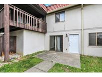 Exterior of home featuring a balcony, white stucco, tile roof, front door, and concrete patio at 8545 La Corrida Ct, Indianapolis, IN 46227