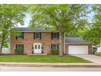 Charming two-story brick home with black shutters, white door and a well-manicured lawn at 1127 Junco Dr, Columbus, IN 47203