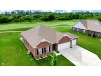 Beautiful brick home with an attached two-car garage on a lush green lawn and an adjacent golf course at 217 Saint Andrews Ave, Edinburgh, IN 46124