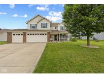Charming two-story home with a three-car garage and a well-manicured lawn featuring a quaint front porch at 2580 Bluewood Way, Plainfield, IN 46168