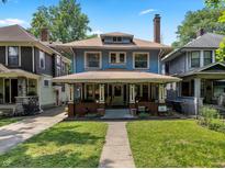 Charming two-story home with a large front porch, well-maintained lawn, and inviting curb appeal at 552 Woodruff Pl W Dr, Indianapolis, IN 46201