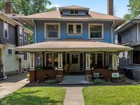Charming two-story home with a covered front porch, landscaped yard, and classic architectural details at 552 Woodruff Pl W Dr, Indianapolis, IN 46201
