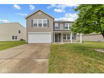 Charming two-story home features a two-car garage, covered front porch, and well-manicured lawn at 5637 Woodland Trace Blvd, Indianapolis, IN 46237