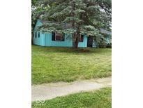 Charming single-story home with vibrant blue siding and a well-maintained front yard, shaded by a mature tree at 5938 Price Ln, Indianapolis, IN 46254
