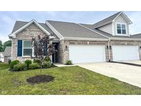 Charming townhome with brick facade, two-car garage, and freshly landscaped front yard at 6350 Stallion Way, Indianapolis, IN 46260